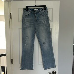 Risen jeans.  Never worn. Distressed light blue fabric.  Raw hem on back side
